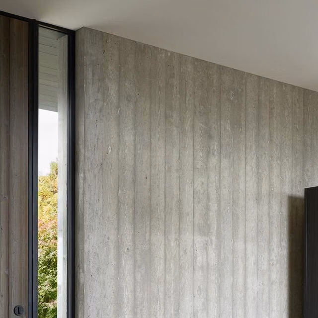 board formed concrete texture close up photograph - Fieldworks Custom Concrete on Instagram: "Dual-sided vertical board formed concrete inside and out at our Madrona House project, designed by Daniel Toole Architecture. Floor-to-ceiling length planks eliminate butt seams and retain the wood grain texture on the face of the concrete, complete with a cast in place light switch. #customconcrete #fieldworksconcrete #concretedesign"