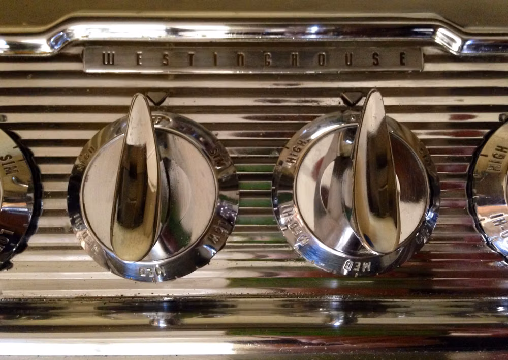 1930s chrome kitchen appliance photograph - Knobs on my stove top.  The chrome detail looks like it belongs on a classic car.  Late 1950's.