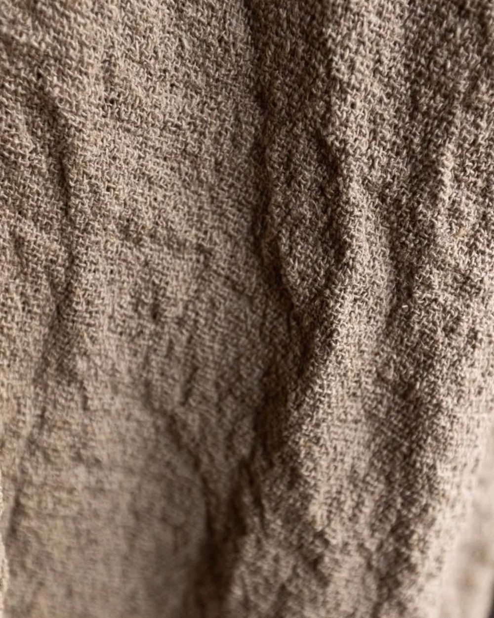 worn natural linen wrinkles macro photograph - This incredibly beautiful material actually brought us some adventures. It's woven in raw linen yarn, thick and unpolished, and we expected after wash it gives much shrinkage. We love to use this special kind of imperfection, so we boiled fabric to highlight the little wrinkles and add more, then boiled pants after sewing (it was not an easy task for my mum to count length correctly with all the double shrinkage and alive structure, so we ended up testing on a few sample pairs).   DREAMERS pa...
